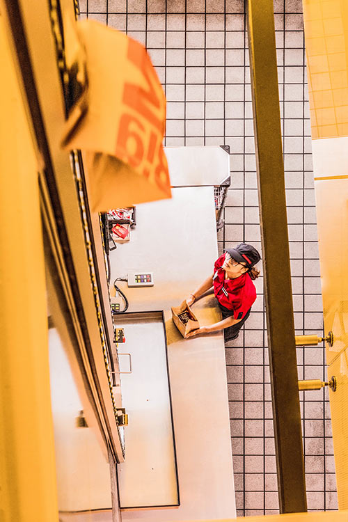 Young woman working in the Flagship Store of Mc Donalds Restaurant 