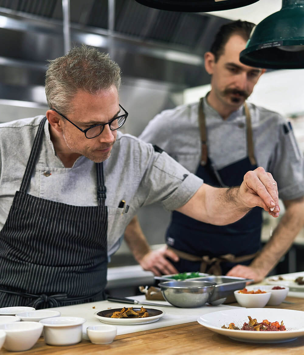 Jonathan Gushue seasons chanterelles on a plate