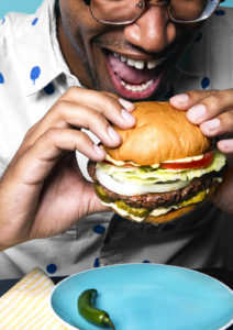 Black guy biting into a vegan burger
