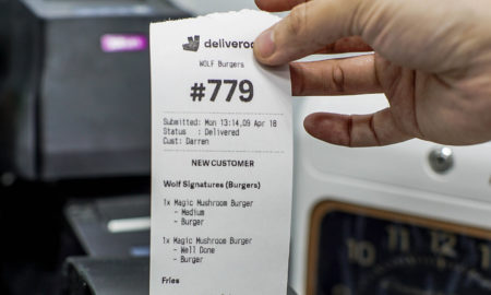 Deliveroo order receipt in commercial kitchen.