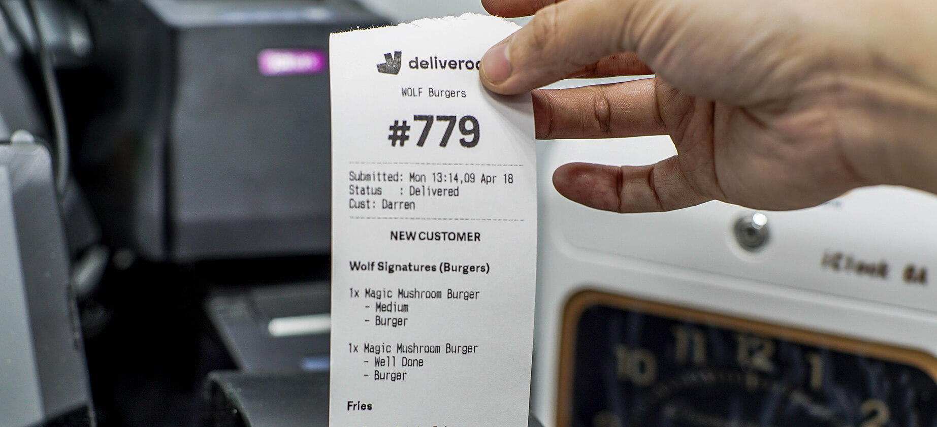 Deliveroo order receipt in commercial kitchen.