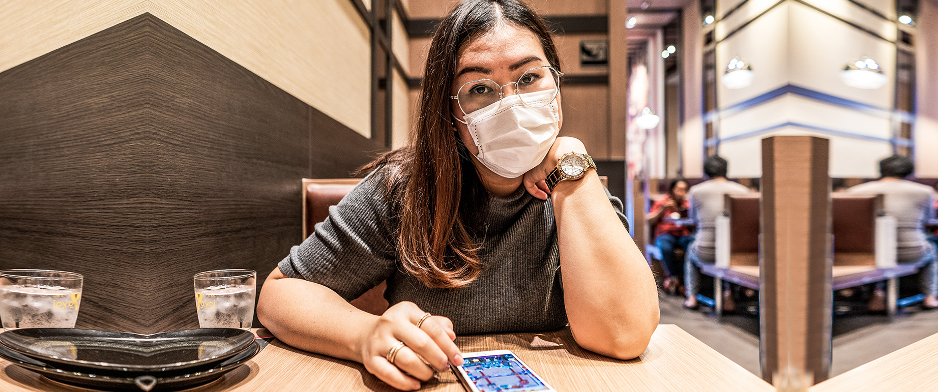 Frau bestellt Essen mit Smartphone im Restaurant