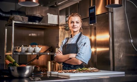 Una joven cocinera en la cocina de un restaurante encarna a las Food Trernd Female Connoisseurs