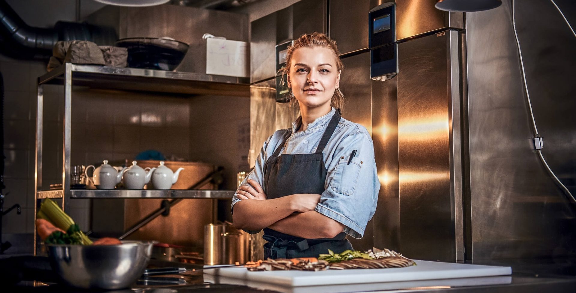 Una joven cocinera en la cocina de un restaurante encarna a las Food Trernd Female Connoisseurs