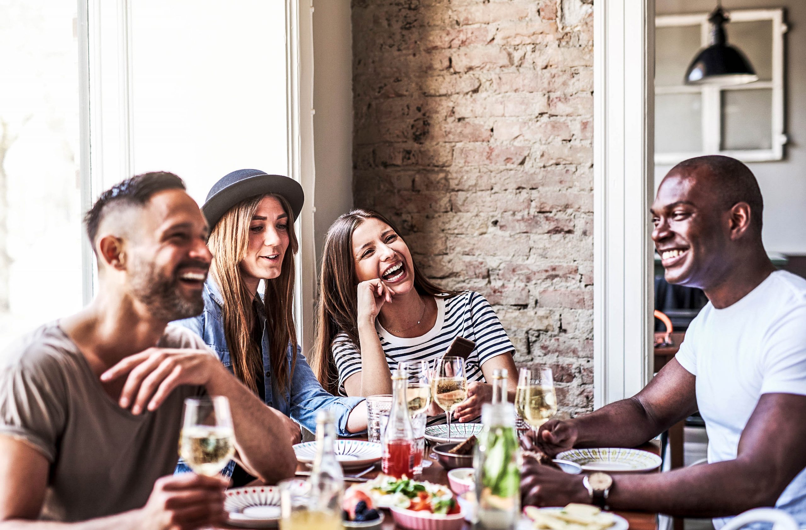 Junge Menschen sitzen im Restaurant - etwas das die Menschen in der Pandemie mit am meisten vermissen.