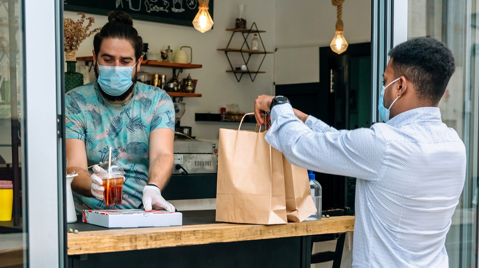 Ein Restaurantbetreiber hat eine To-Go-Fenster eingerichtet an dem sich Kunden ihr Essen abholen können. 