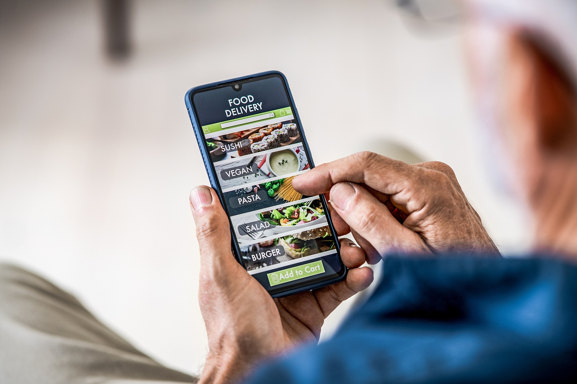 Elderly man ordering food via app at home or work.