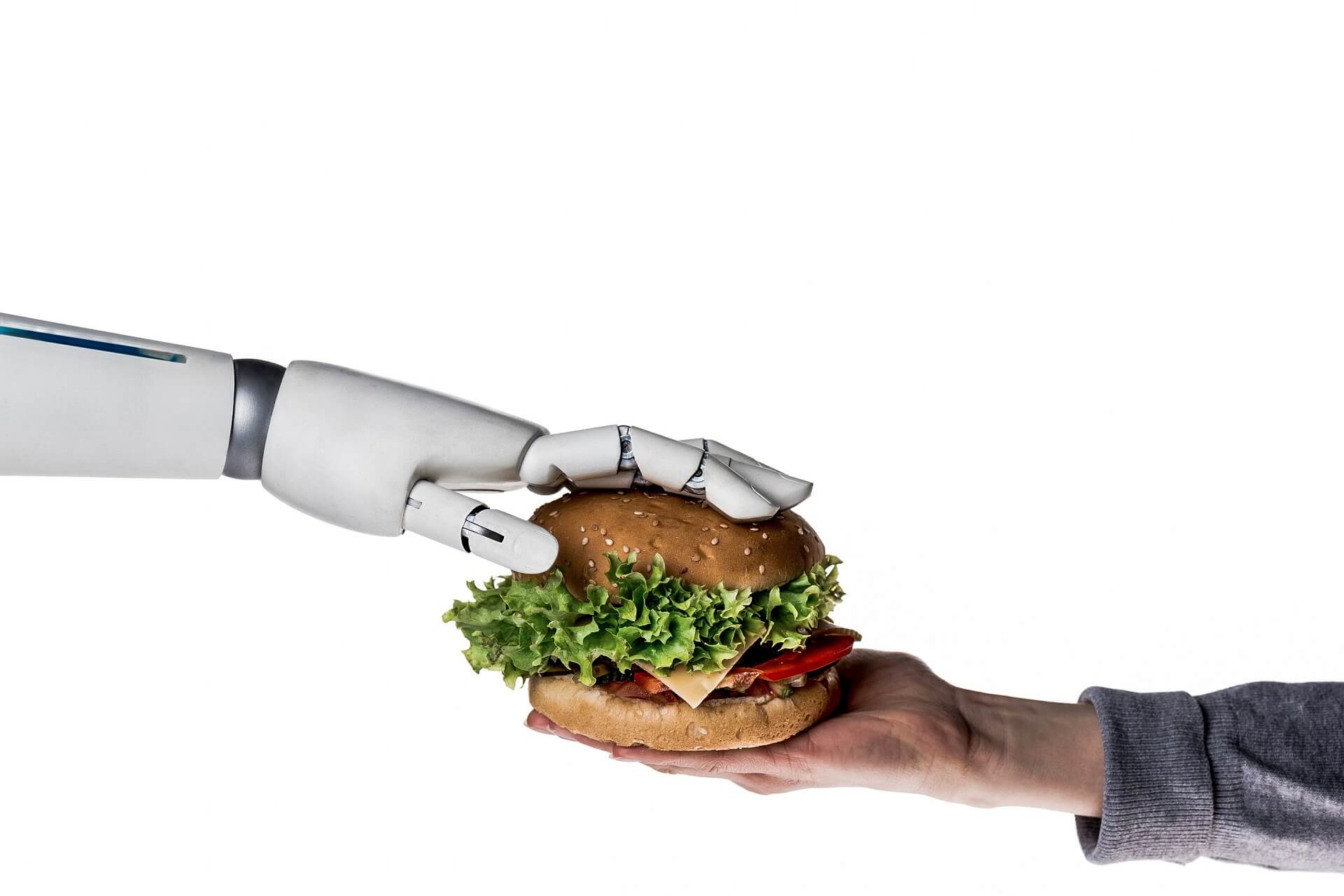 Roboterhand reicht Mensch einen Burger