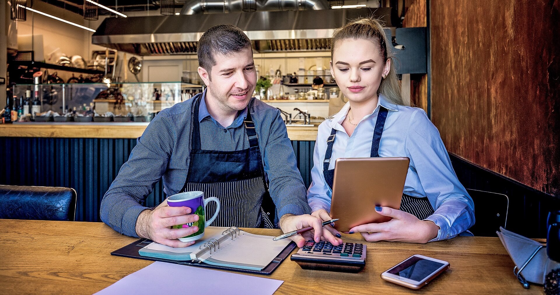 Restaurateurs sitting in the uest room checking their operating costs. 