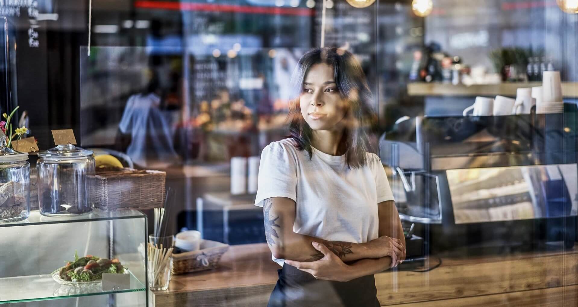 Eine junge Restaurantinhaberin blickt besorgt aus dem Fenster - die Digitalisierung stellt für so manchen einen enormen finanziellen Aufwand dar.