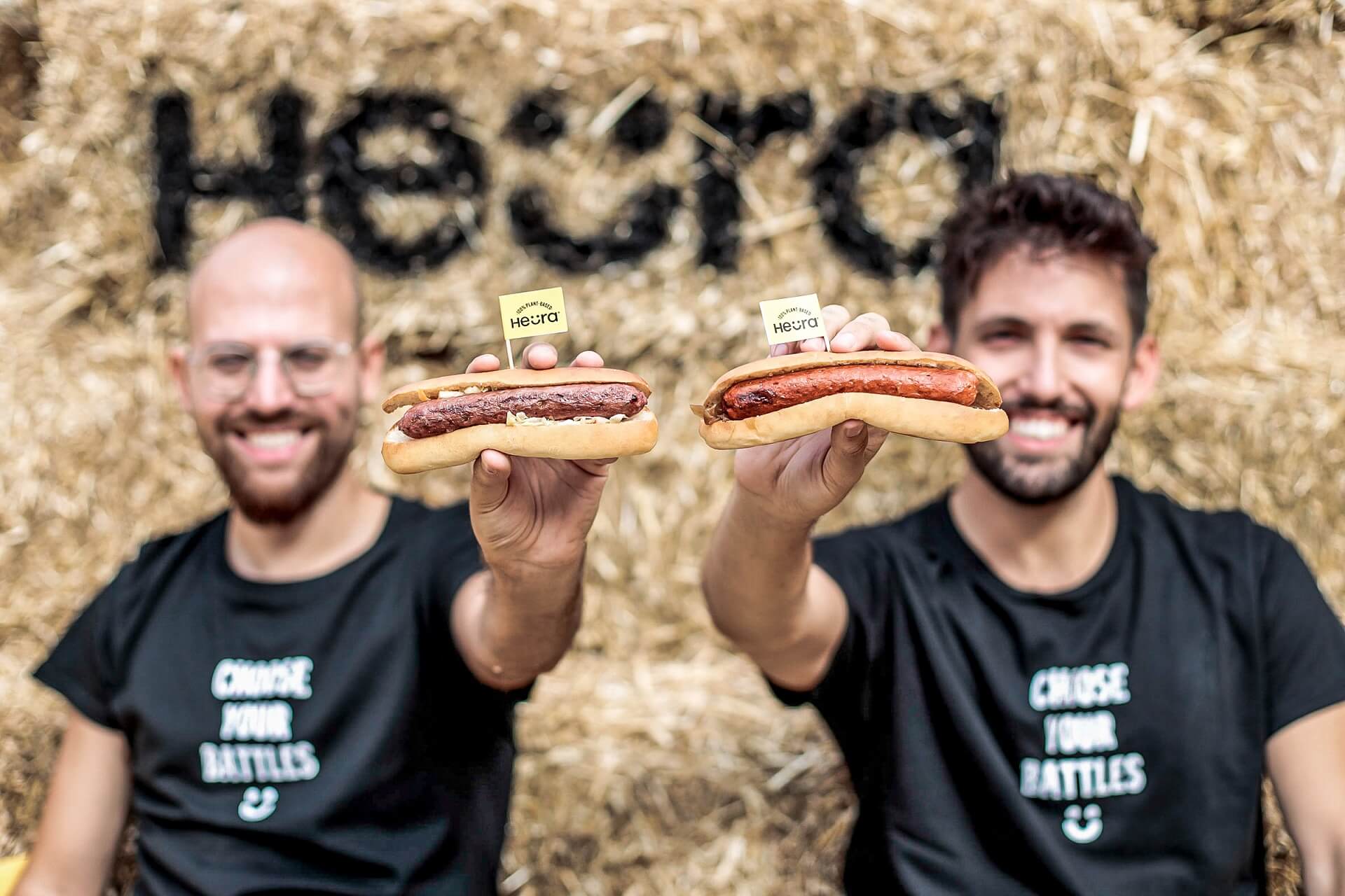 Founders of Heura holding plant based sausages.