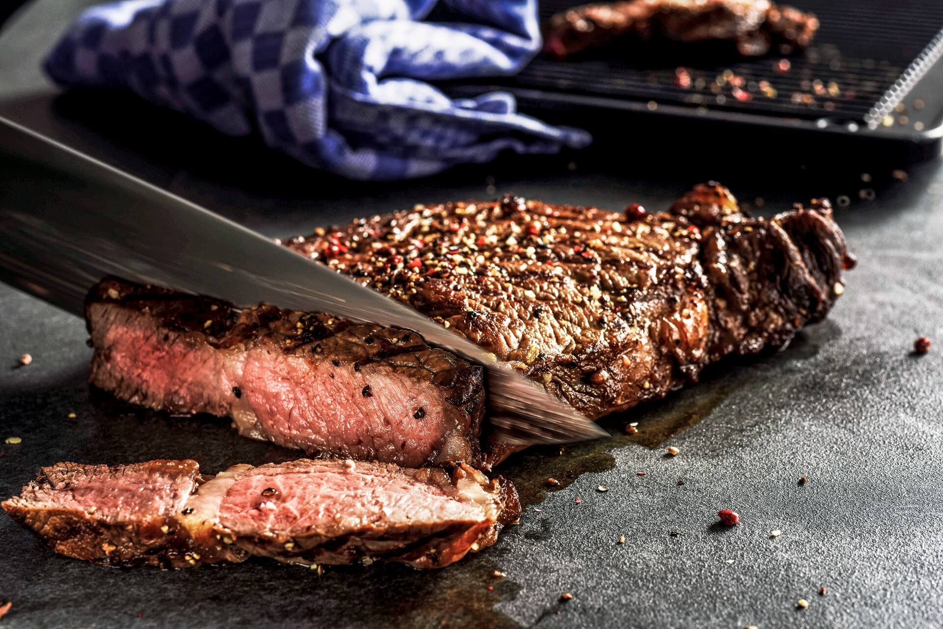 Chef cutting a medium-rare rib-eye-steak from Ojo de Agua - mouth watering!