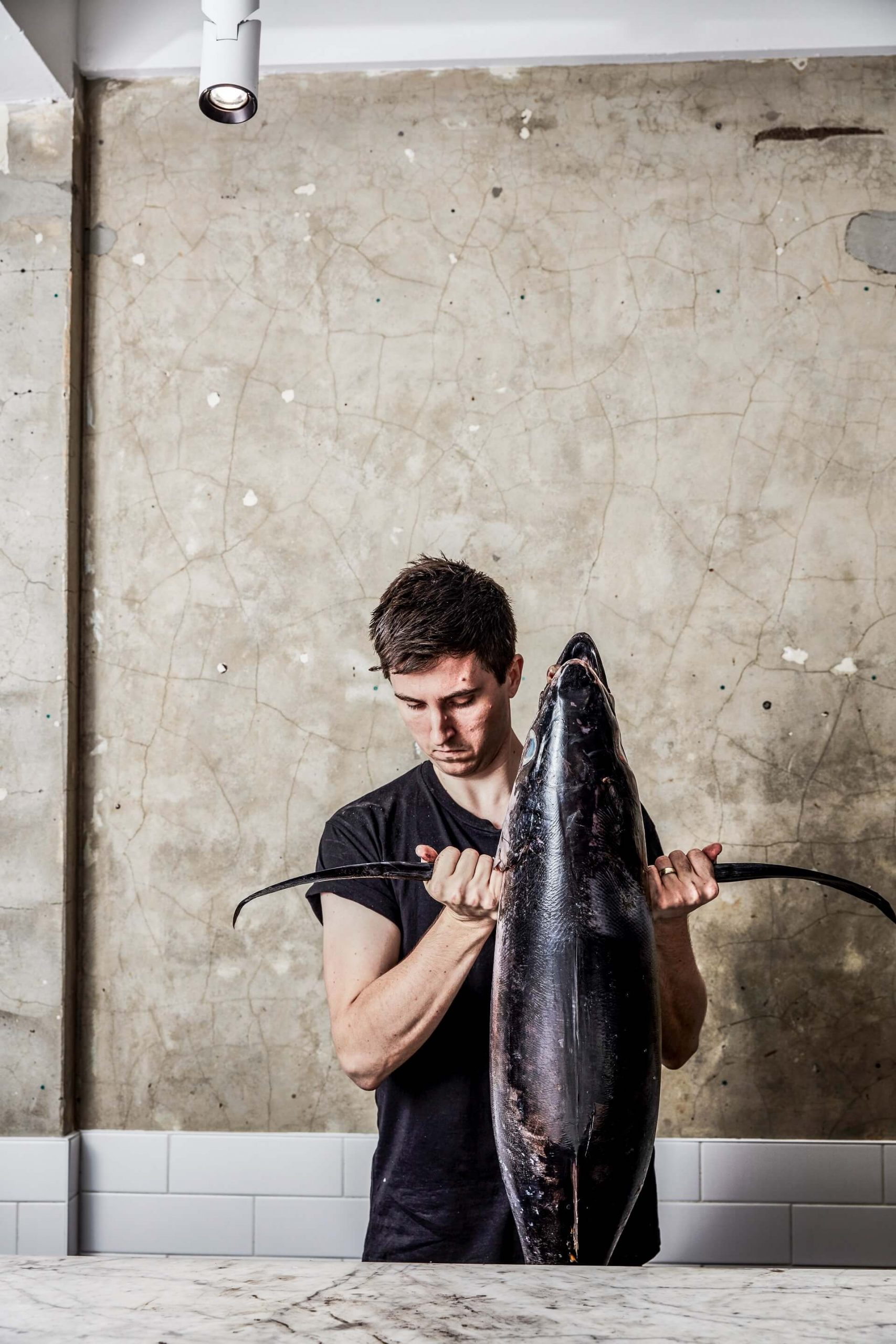 Josh Niland holding a huge fish - he perfects fish drying at his own restaurant 
