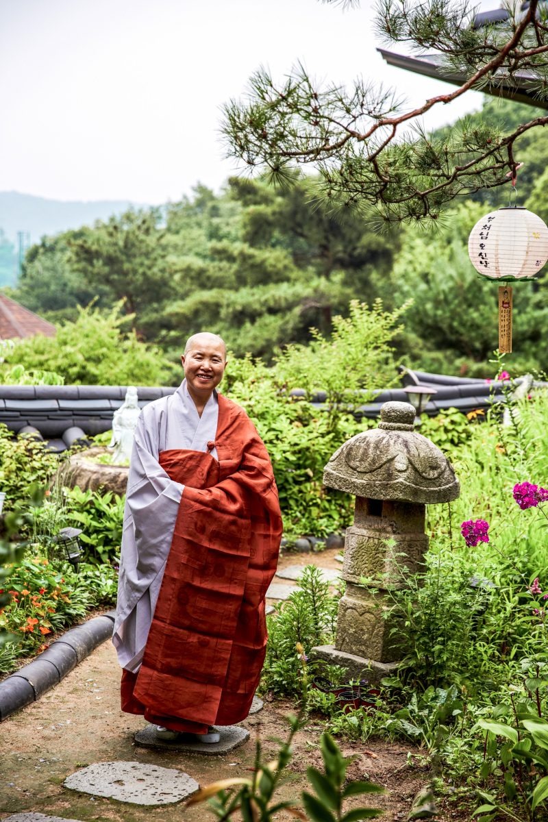 Koreanische Nonne im Garten des Tempels