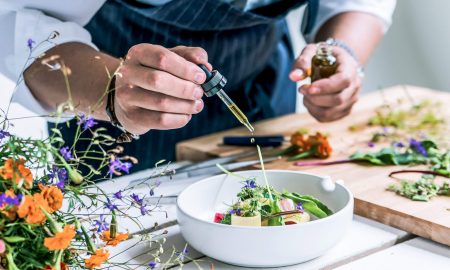 Koch der gerade sein Salat mit ätherischem Öl anmacht