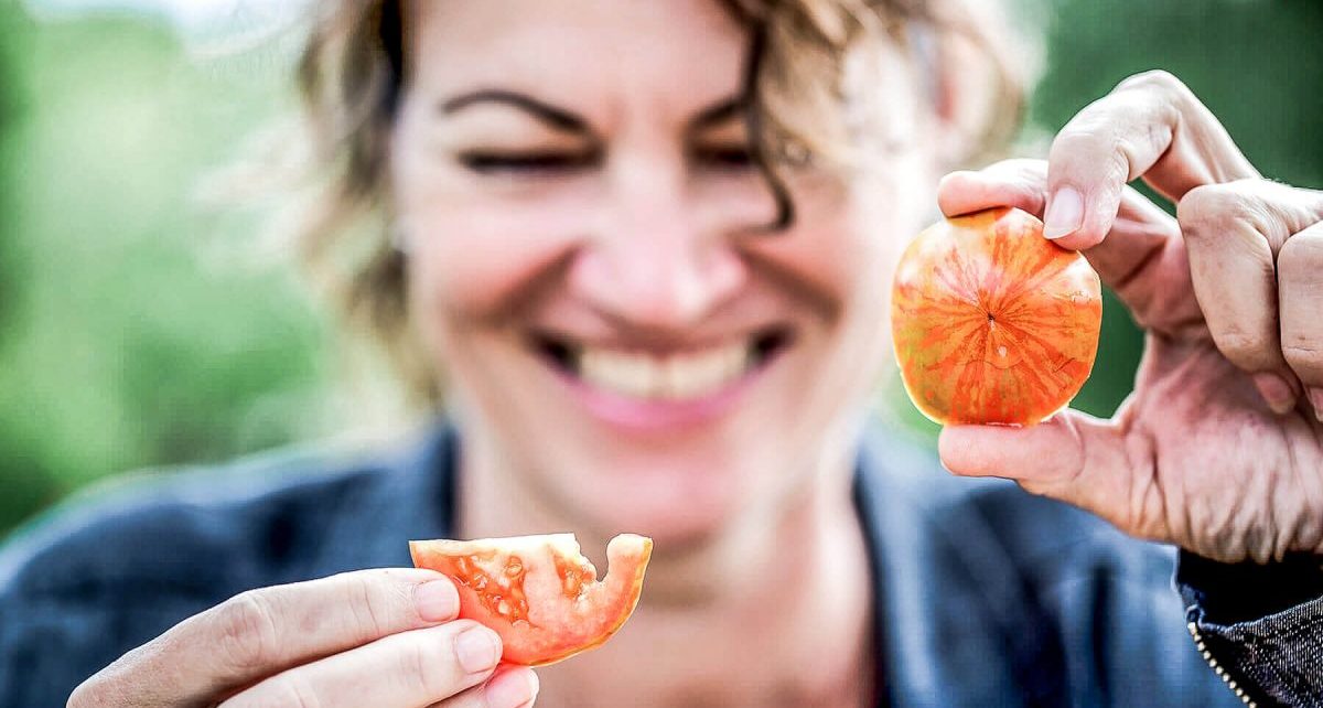 Hanni Ruetzler smiling with tomatoes in hand