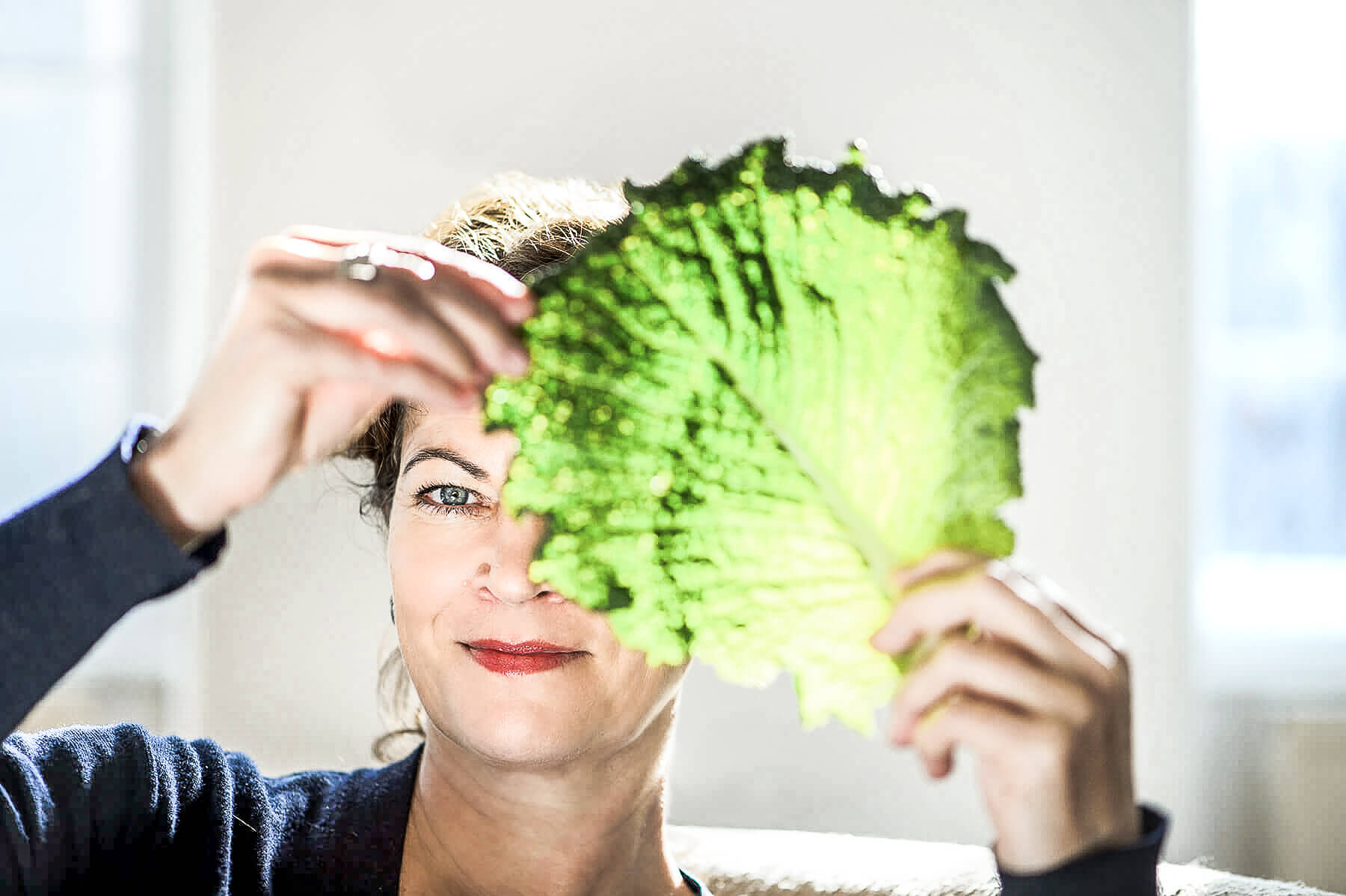Hanni Rützler holding a salad leaf in front of her face to promote more sustainability in restaurants 