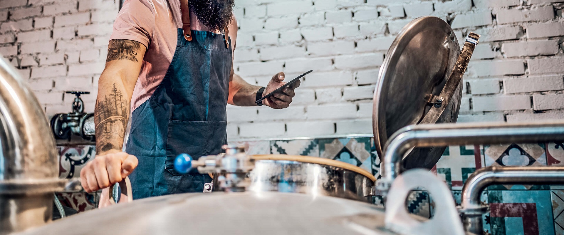 Men working at brewery and using a tablet application for fermentation process