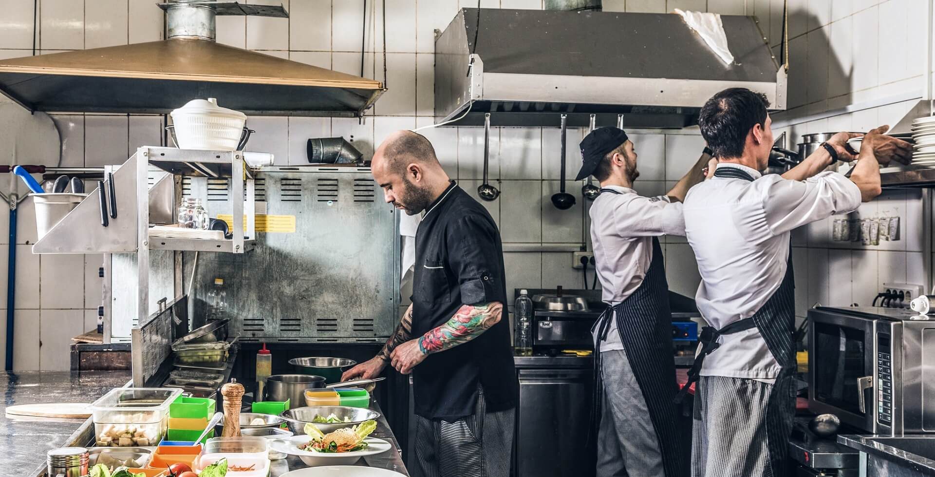 Cocineros profesionales que trabajan eficazmente gracias a una gran organización hostelera