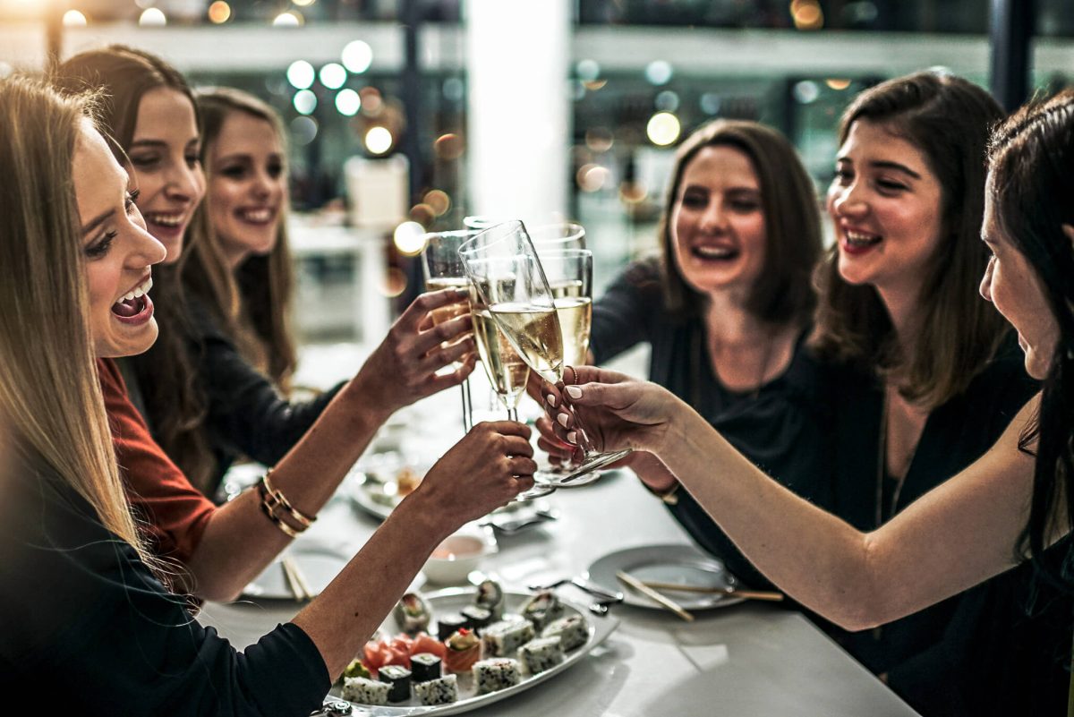 Glückliche Gäste stoßen mit einem Glas Champagner an