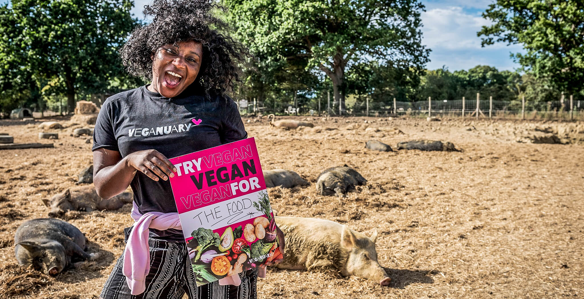 Schwarze Frau mit Plakat dass für eine vegane Ernährung im Januar (Veganuary) wirbt