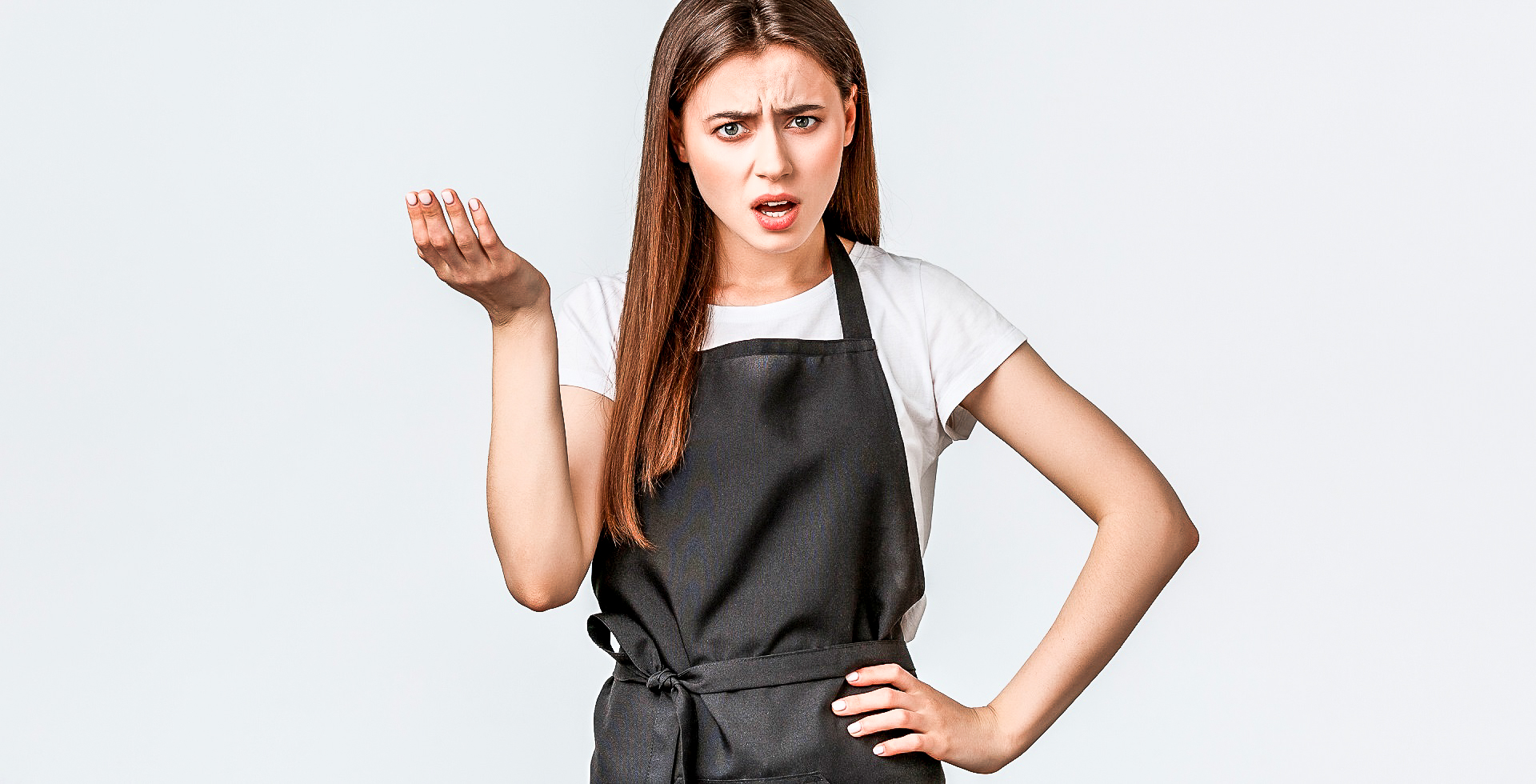 Young woman wearing a black apron complaining.