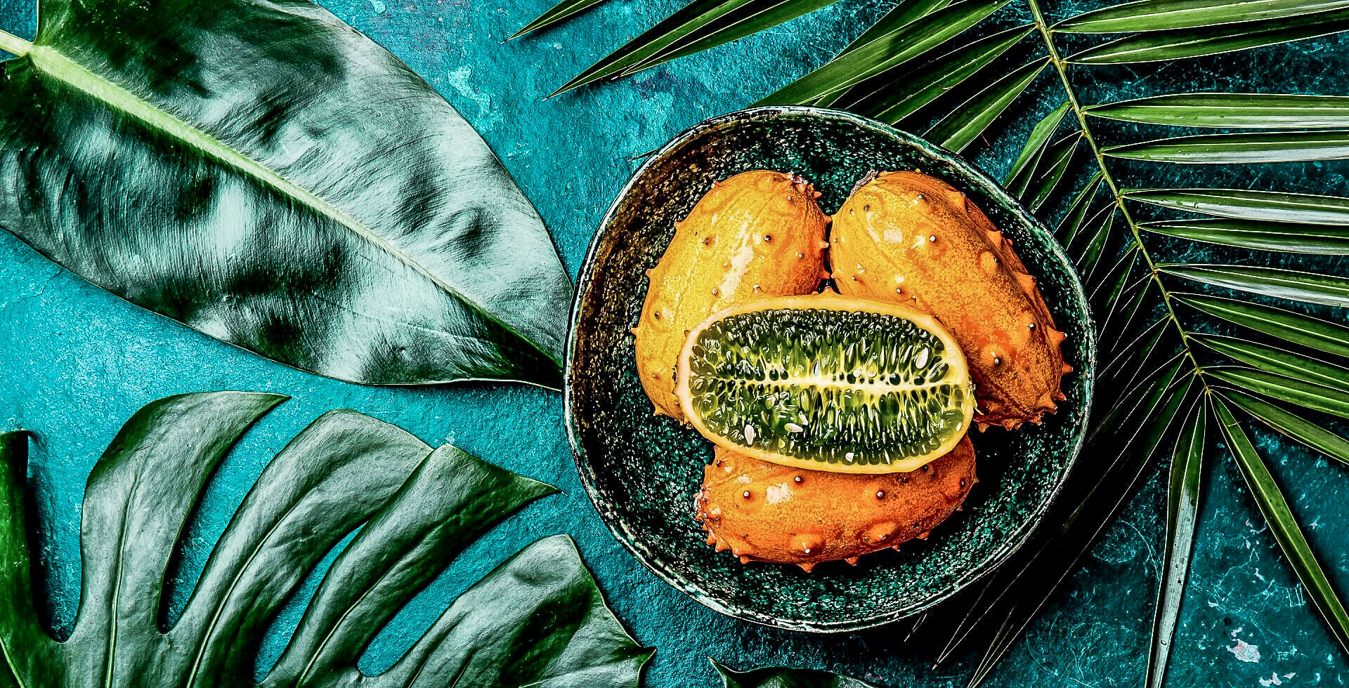 Tropical fruit Kiwano cut open and from mthe outside.