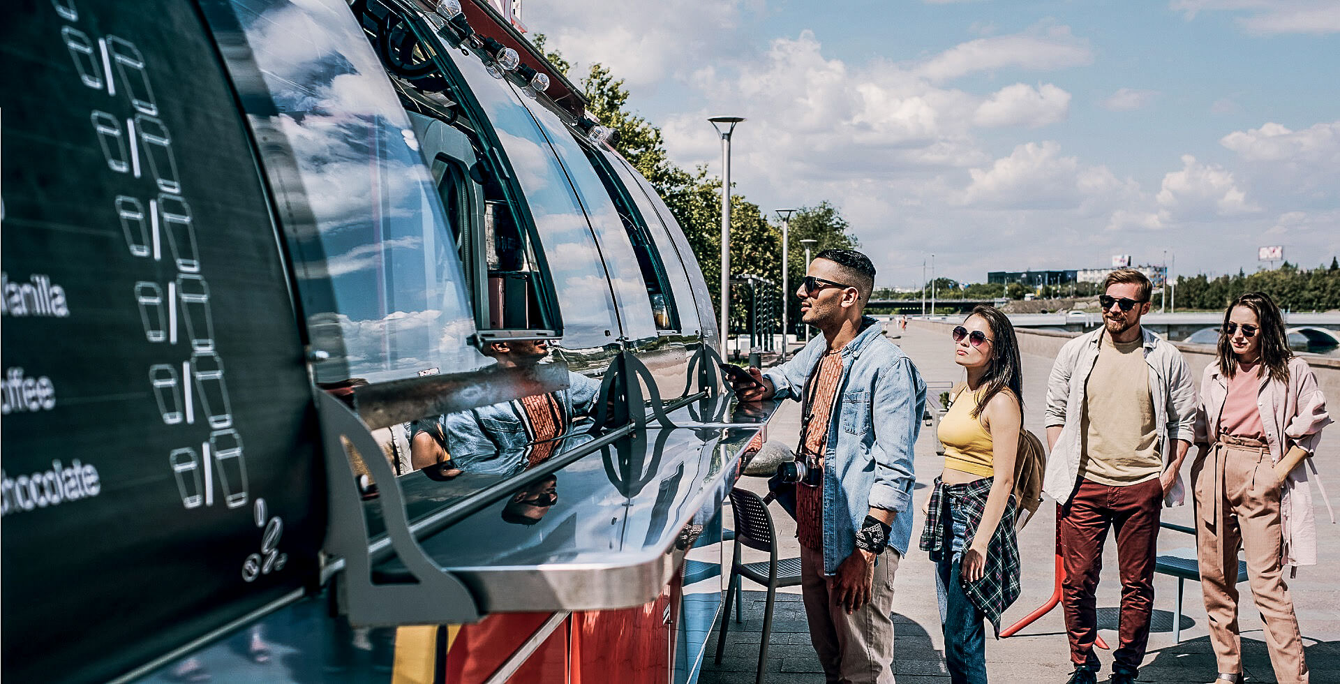 Kunden warten vor einem Foodtruck auf ihr Essen