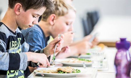 Two boys eating school meals