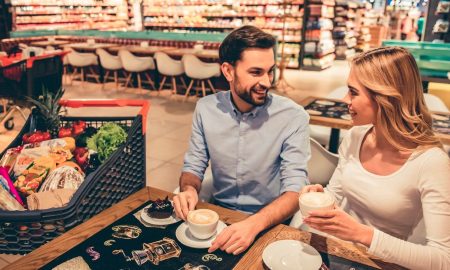 Pareja bebiendo un capuchino en un supermercado gastronómico