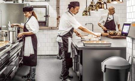 Eine Gruppe Köche arbeitet in einer Küche die mit Hilfe von KI Food Waste in der Gastronomie reduziert
