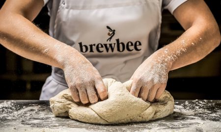 Un empleado de Brewbee amasa la masa de pizza