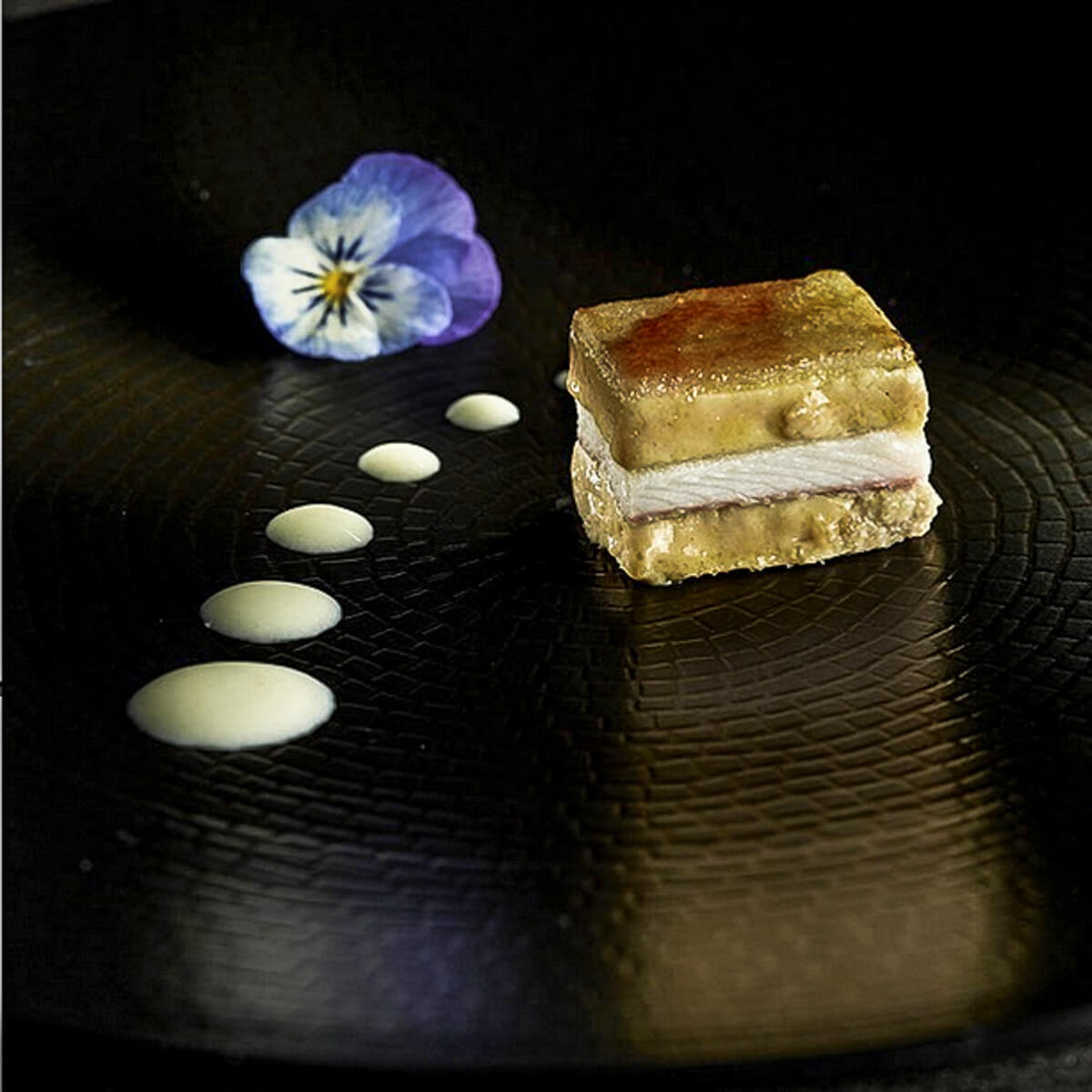 Signature Dish von Martin Berasateguí: Millefeuille mit geräuchertem Aal, Foie Gras, Lauchzwiebelcreme und karamellisiertem grüner Apfel.