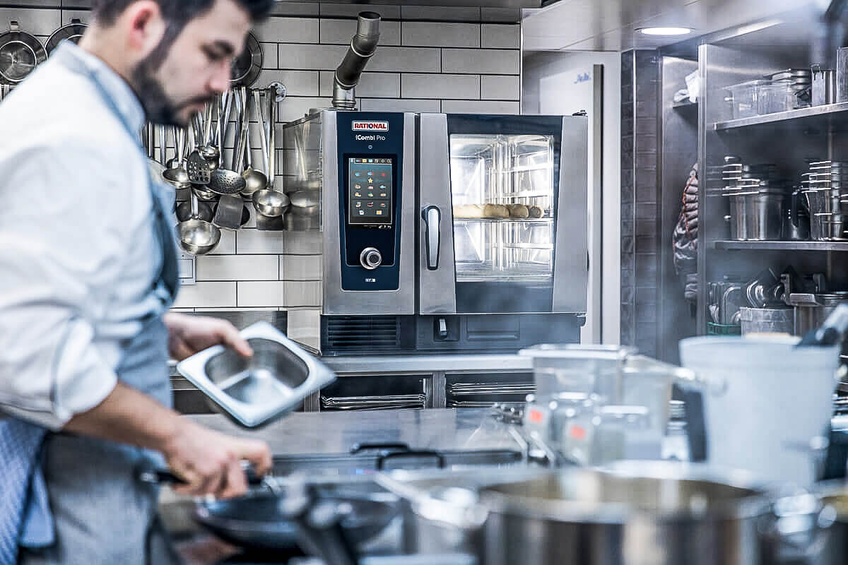 Cada vez son más las grandes empresas de catering que renuncian a las parrillas de gas o carbón en sus cocinas y cocinas centrales en favor de cocinas de vapor mucho más eficientes energéticamente, como los hornos mixtos de Rational.