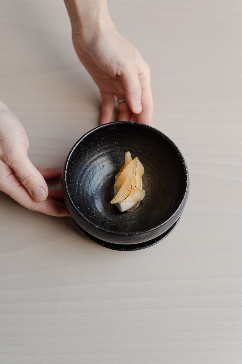 A pre-dessert on a black plate