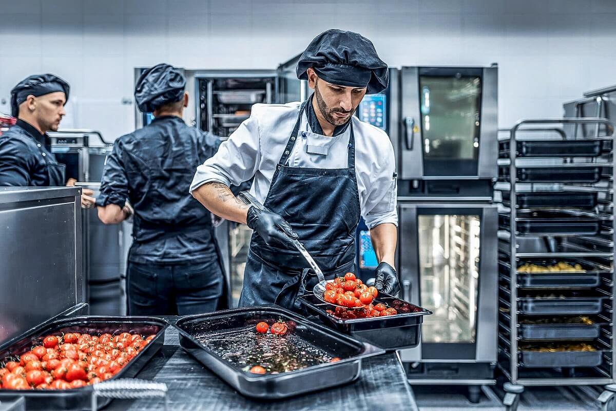 Tomaten werden von einem Koch umgefüllt