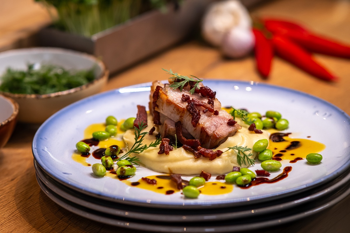 Fleisch auf einem Teller mit Edamame und Kartoffelpüree angerichtet 