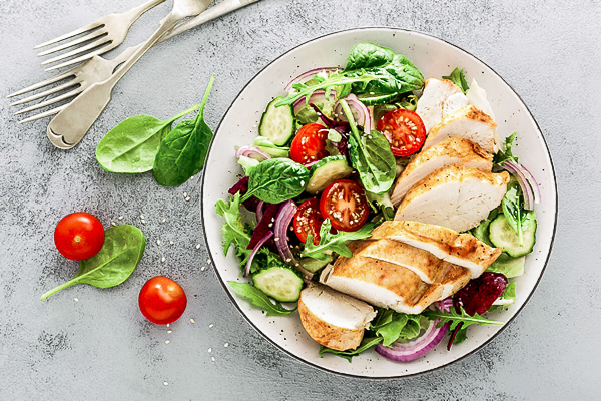 Dressed salad with chicken strips.