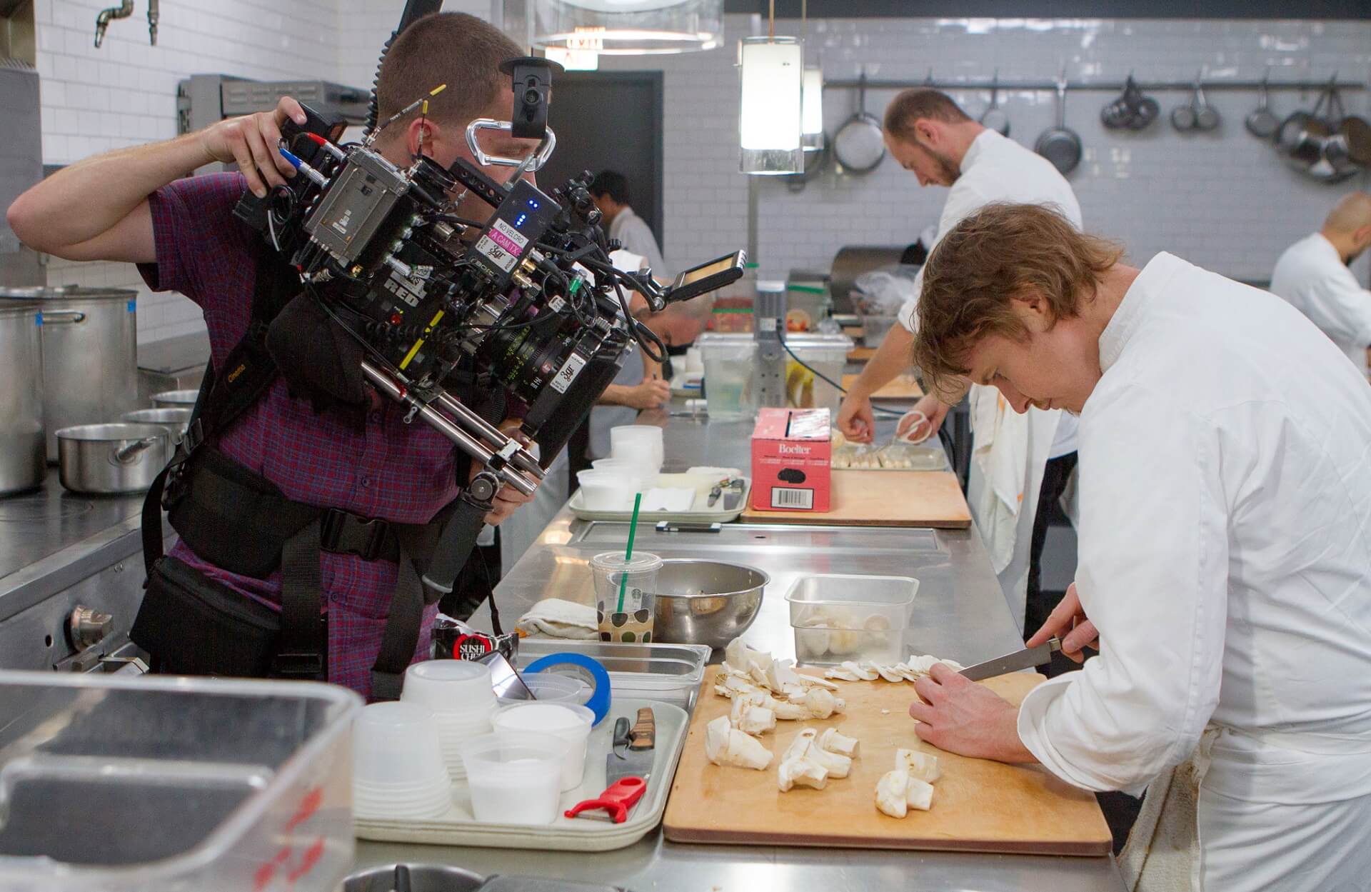 A camera team is filming Grant Achatz in his professional kitchen