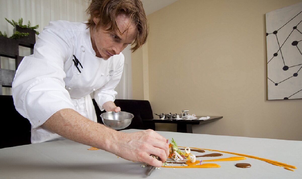 Grant Achatz as he arranges a dish on a table