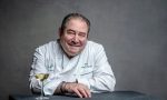 Portrait of Emeril Lagasse with a wine glass in front of him