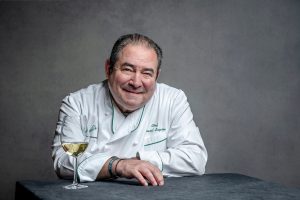 Portait von Emeril Lagasse mit einem Weinglas vor ihm