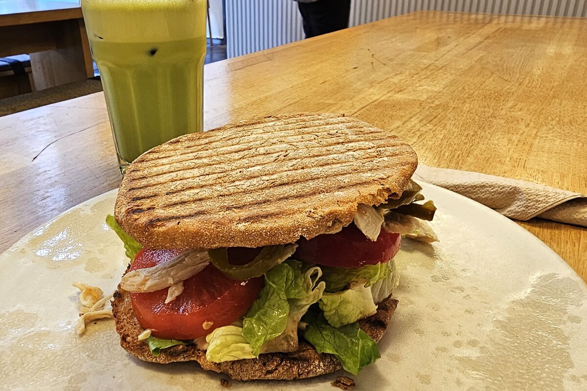 Matcha Late mit einem Vollkornsandwich - gefüllt mit Tomate und Salat.