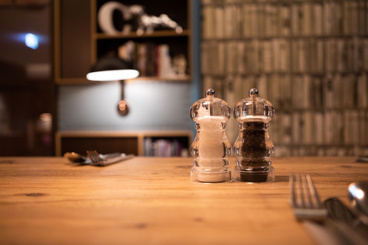 Salt and pepper shakers on a set table.