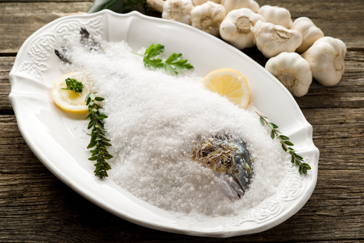 Sea bream in a salt crust on a white plate.