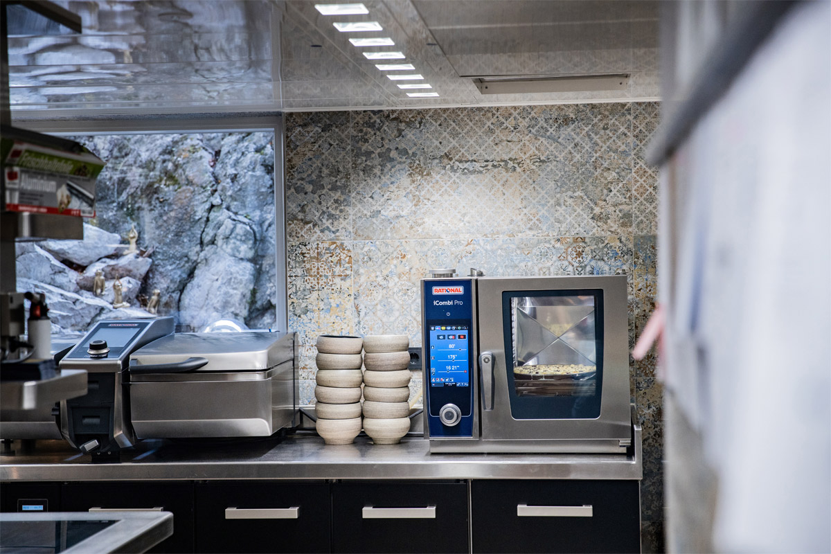 RATIONAL iCombi Pro XS combi oven and iVario XS cooking system in compact professional kitchen.