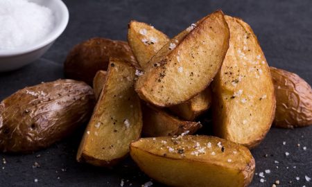 Kartoffelwedges mit Salz auf schwarzem Brett