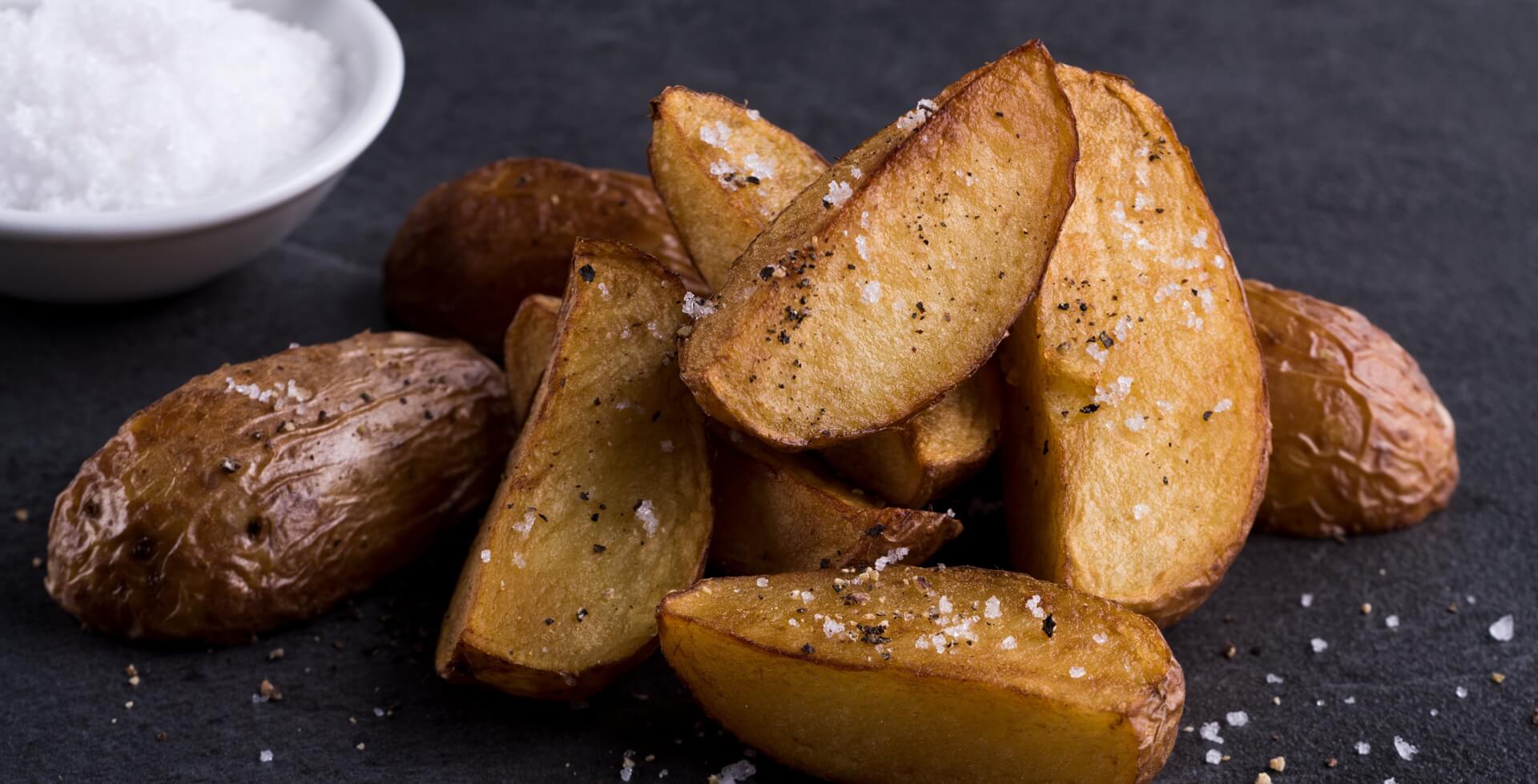 Kartoffelwedges mit Salz auf schwarzem Brett